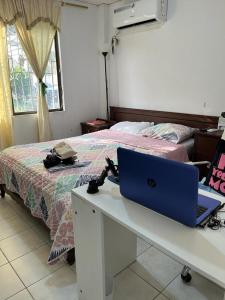 1 dormitorio con ordenador portátil en un escritorio junto a la cama en Una Joya brillante, en San Antonio