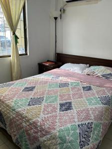 Una cama con edredón en un dormitorio en Una Joya brillante, en San Antonio