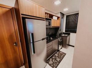 a small kitchen with a stainless steel refrigerator at Apartamento Luxo Executivo in Bento Gonçalves