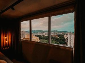 a window in a room with a view of a city at Apartamento Luxo Executivo in Bento Gonçalves