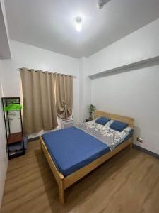 a bedroom with a blue bed in a room at One Bedroom Condo with fast wifi at Eastwood Lafayette tower Quezon city in Manila