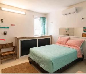 1 dormitorio con 1 cama grande y 1 silla en Casa paz, en Isla Mujeres