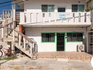 un edificio blanco con una puerta verde y escaleras en Casa paz, en Isla Mujeres