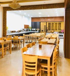 a dining room with wooden tables and chairs at An Phu Hotel Da Lat in Da Lat