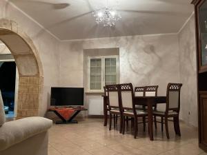 una sala da pranzo con tavolo, sedie e TV di Appartamento Marchesini a Ceccano