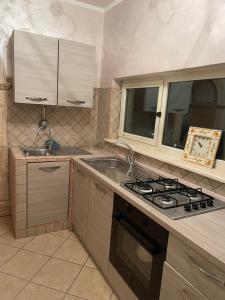 una cucina con piano cottura e lavandino di Appartamento Marchesini a Ceccano