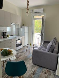 een keuken en een woonkamer met een bank en een tafel bij 1922 Historic House in Kavala +21 foto's