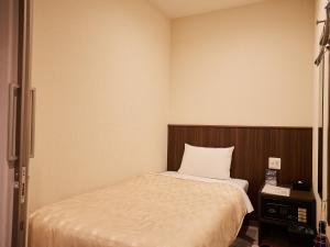 ein kleines Schlafzimmer mit einem Bett und einem TV in der Unterkunft Grand Cabin Hotel Naha Oroku for Men / Vacation STAY 62323 in Naha