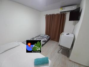 um quarto com uma cama com uma televisão e um quarto com em Posada Lia Centro em Providencia