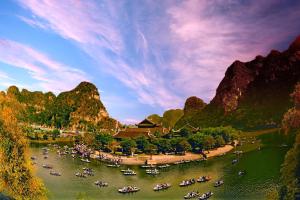 eine Gruppe von Booten in einem Fluss mit Bergen in der Unterkunft Truong Son Luxury Homestay in Ninh Bình