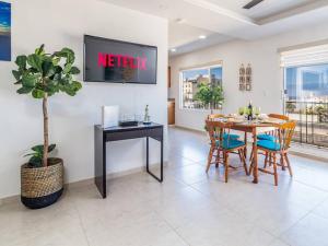 a dining room with a table and chairs and a tv at Ocean View 15 Gardenhaus in Tijuana