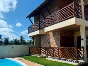 a building with a balcony next to a swimming pool at Eloa Flats in Luis Correia