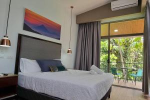 a bedroom with a bed and a balcony with a table at Villas Töcu-Casa Perezoso in Fortuna +35 photos