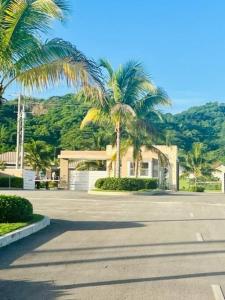 a parking lot with palm trees in front of a house at FlowerPot by the Sea in Lucea