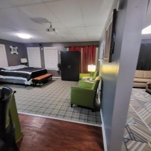 een woonkamer met een bed en een groene stoel bij Tranquility & Minutes from DTW in Romulus