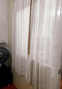 a white curtain on a window in a room at Loft aconchegante - Centro Niterói in Niterói