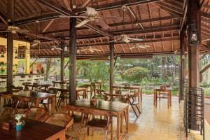 um restaurante vazio com mesas e cadeiras de madeira em Pavillon d'Orient Boutique Hotel em Siem Reap