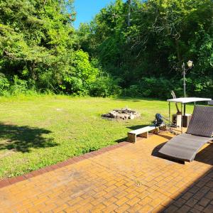 a patio with a bench and a picnic table in a park at Tranquility & Minutes from DTW in Romulus