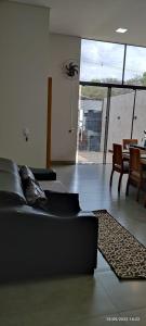 a living room with a couch and a table and chairs at Residência Cidade Verde 3 in Maringá