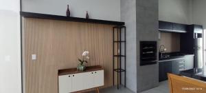a kitchen with a wall with a vase of flowers on it at Residência Cidade Verde 3 in Maringá