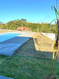 a swimming pool in a yard with a plant at Espaço Mattigor in Caçapava