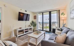 a living room with a couch and a tv at 1 Bedroom -1 Bath With Ocean Views At Ocean Trillium 302 in New Smyrna Beach