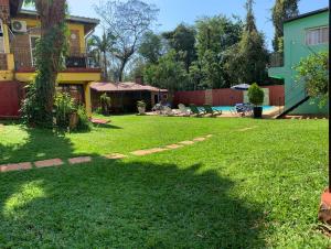 un patio con piscina y una casa en Apart JM en Puerto Iguazú