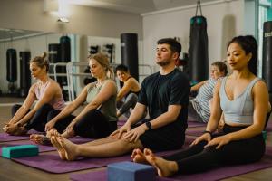 a group of people sitting in a yoga class at Sojourn Apartment Hotel - Ghuznee in Wellington