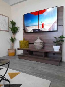 a living room with a flat screen tv on a wall at Square One Properties Inc. in Roseau