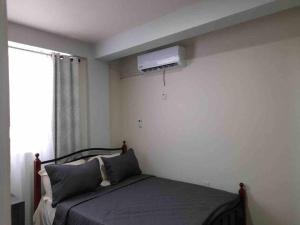 a bedroom with a bed with a television on the wall at Square One Properties Inc. in Roseau