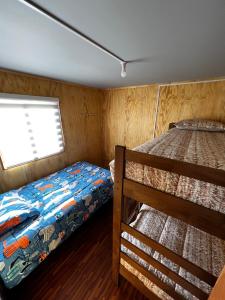 1 dormitorio con 2 literas y ventana en Cabaña Puerto Sánchez RYS Patagonia A, 