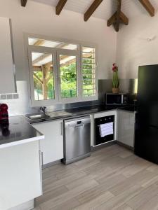 a kitchen with a sink and a dishwasher at Villa Varte in Baie-Mahault