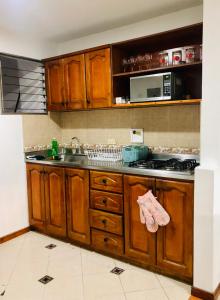 a kitchen with wooden cabinets and a sink at Full Apartamento en Medellin Itagui Centro de la moda Mayorista Poblado in Itagüí