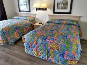 two beds in a hotel room with a colorful quilt at Eldorado Motel, New Castle in New Castle