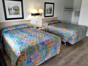 um quarto de hotel com duas camas com capas coloridas em Eldorado Motel, New Castle em New Castle