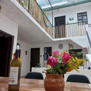 - une bouteille de vin et un vase avec des fleurs sur une table dans l'établissement El Rinconcito de San Cris, à San Cristóbal de Las Casas