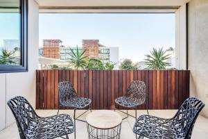 a group of chairs and a table on a balcony at Luxe Eco Suite in Australia's Greenest Building in Sydney