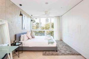 een slaapkamer met een bed en een groot raam bij Sustainable Luxury in Australia's 1st Passive Apartment in Sydney