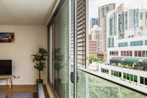 Habitación con ventana grande con vistas a la ciudad. en Sleek Chinatown Pad in the Heart of the CBD en Sídney