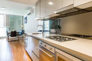a kitchen with a stove and a counter top at Sleek Chinatown Pad in the Heart of the CBD in Sydney
