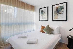 a bedroom with a white bed with two pillows on it at 'Mini Manhattan' Potts Point Harbourview Retreat in Sydney