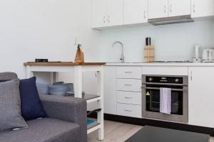 a living room with a couch and a kitchen at Urban Oasis Custom Made for Cosmopolitan Living in Sydney