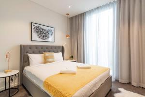 a bedroom with a large bed with a yellow blanket at Sunny Courtyard Escape in Sydney's Little Italy in Sydney