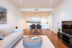 a living room with a couch and a table at Sunny Courtyard Escape in Sydney's Little Italy in Sydney