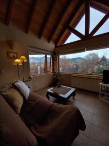 un salon avec un canapé et une grande fenêtre dans l'établissement Tranquera's house, à San Martín de los Andes