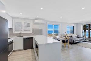 a kitchen and living room with a view of the ocean at Ocean Pines Apartment 5 in The Entrance