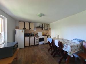 a kitchen with a table and a white refrigerator at Casa cu flori in Tuzla +15 photos