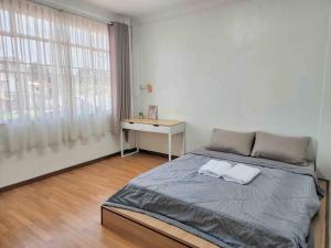诗巫诗巫红色屋顶民宿 ｜Redroof Homestay的一间卧室，里面有一张床、一张桌子和一扇窗户