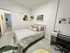 a white bedroom with a bed and a tv at Apartamento praia de Copacabana in Rio de Janeiro
