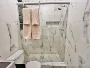 a white bathroom with a shower and a toilet at Apartamento praia de Copacabana in Rio de Janeiro